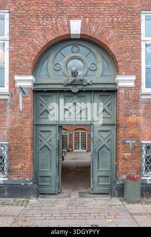Historisches grünes Holztor mit Ziegelbogen in Kopenhagen, Dänemark, Altstadtarchitektur Stockfoto