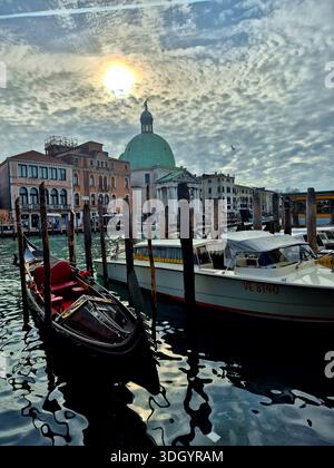 Gondeln und Wassertaxis in der Lagune mit der Kirche San Simeone Piccolo im Hintergrund, Venedig, Italien Stockfoto
