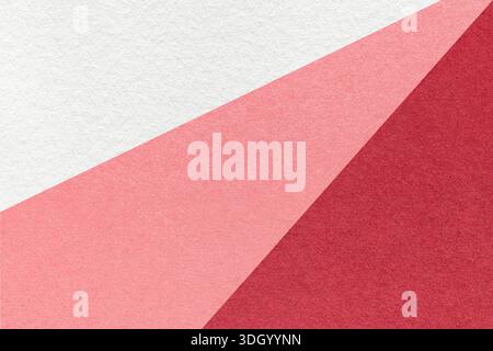 Abstrakter geometrischer weißer rosa roter Papierstrukturhintergrund mit diagonaler Spaltung. Dekorativer Hintergrund mit Strahlenmuster. Stockfoto