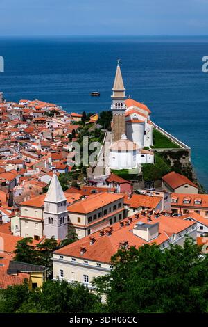 Blick aus einem hohen Winkel auf die St. George's Pfarrkirche und ihren Glockenturm mit Blick auf die rot gekachelten Dächer der Altstadt. Stockfoto