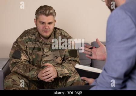 Zwei professionelle Männer, die ein ernsthaftes Gespräch führen, während sie auf einem Sofa sitzen Stockfoto