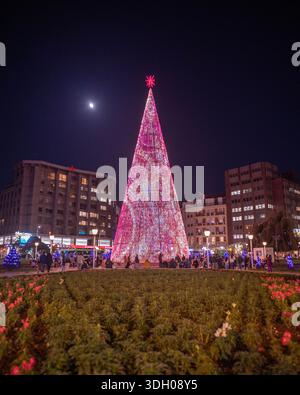 Riesiger beleuchteter Weihnachtsbaum auf einem Stadtplatz bei Nacht. Stockfoto