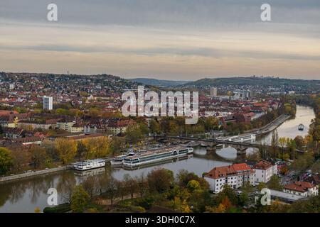 Erhöhter Panoramablick auf Würzburg mit Kreuzfahrtschiffen, Brücken und dichten Wohnvierteln auf den Main. Stockfoto