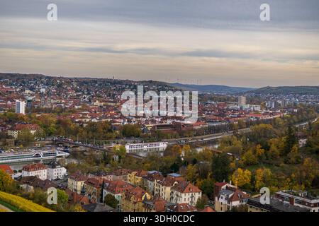 Weites Hochpanorama von Würzburg mit dem Main mit Brücken und Passagierkreuzschiffen umgeben von dichtem Stadtbau. Stockfoto