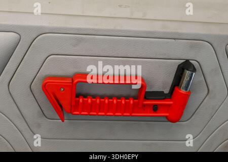 Notsicherheitshammer auf grauer Busverkleidung zum Brechen von Glasscheiben, um dem Fahrzeug bei Gefahr oder Unfall zu entkommen, bietet sicheres Gefühl Stockfoto