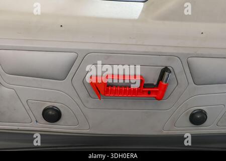 Roter Notfallhammer montiert an grauer Fahrzeugdecke bereit für dringende Sicherheitssituation und sichere Flucht mit zuverlässiger Unfallrettung Stockfoto