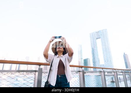 Frauen, die das Stadtbild von Dubai Marina mit moderner futuristischer Architektur in den Vereinigten Arabischen Emiraten beobachten – Stockfoto Stockfoto