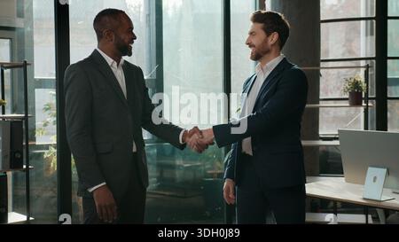 Zwei Männer Business Team multiethnische Geschäftsleute Handschütteln sprechen im Büro Teamarbeit Partnerschaft multinationale Zusammenarbeit Kollegen schütteln die Hand Stockfoto