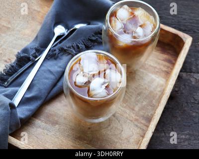 Erfrischender Eiskaffee auf einem rustikalen Holztablett Stockfoto