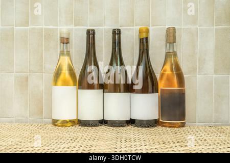 Allgemeiner Blick auf eine Wand, die mit gefüllten und verklebten Weinflaschen bedeckt ist, wodurch ein durchscheinendes Mosaik entsteht, in dem natürliches Licht die Töne des conte hervorhebt Stockfoto