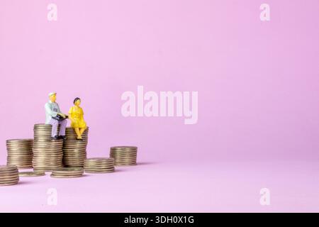 Seniorenpaar auf Münzstapeln Vorsorgeplan Stockfoto