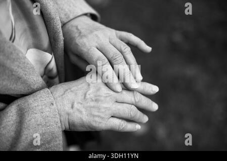 Nahaufnahme der Hände älterer Frauen, die im Freien sanft aneinander liegen. Stockfoto
