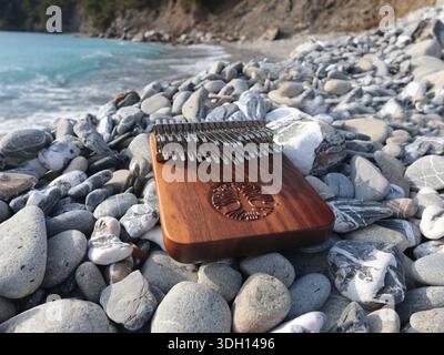 Kalimba-Musikinstrument auf Steinen auf dem Seeweg. Natur in der Nähe von Bergen, Musik und Meditation. Entspannung und psychische Gesundheit. Stockfoto