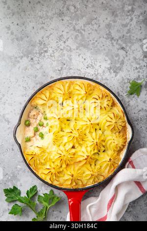 Lachs-Hirtenkuchen. Fisch in cremiger Sauce, Kartoffelpüree und Gemüseauflauf in Emaille-Gusseisenpfanne. Draufsicht Stockfoto