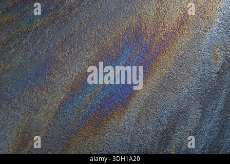 Farbenfrohe Ölleckenmuster auf Asphalt Stockfoto
