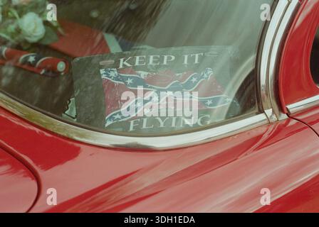 Ein klassisches Buick Special Automobil mit der ersten Nationalflagge der Konföderierten Staaten von Amerika (die „Stars and Bars“). Das Fahrzeug, ein Relikt der amerikanischen Automobilgeschichte, wird hier als mobile Präsentation kontroverser Südstaaten-Ikonographie im britischen Kontext umfunktioniert. Die Bilder erforschen den Schnittpunkt der Oldtimer-Kultur und die anhaltende Verwendung von trennenden historischen Symbolen. Diese Gegenüberstellung hebt die Translokation des amerikanischen politischen Erbes und seine verschiedenen Interpretationen in globale Subkulturen hervor. Stockfoto