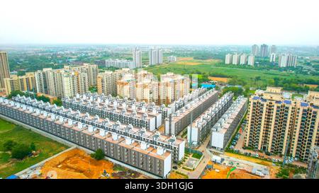 Luftdrohne schoss symmetrisch platzierte Wohnungen, Häuser, mit Wolkenkratzern auf der Rückseite, die massenhaft produzierte modulare Häuser zeigen, die das Immobiliensegment vergrößern Stockfoto