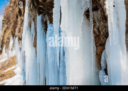 Atemberaubende lange blaue Eiszapfen an sonnigen Wintertagen. Stockfoto