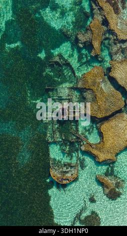 Aus der Vogelperspektive eines Schiffswracks im türkisfarbenen Wasser nahe zerklüfteten Felsvorsprüngen auf Rottnest Island, Western Australia, Australien. Stockfoto