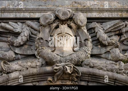 Nahaufnahme einer historischen Steinschnitzerei eines mittelalterlichen Ritterhelms und Wappens am Eingang zum Rathaus von Cardiff, Cathays Park, Cardiff, Wales Stockfoto