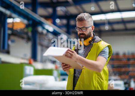 Manager, der die Qualität der Produkte im Werk kontrolliert. Stockfoto