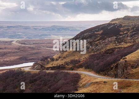 Die A838, Teil der North Coast 500 Route, durchquert felsige Hügel und einsame Moorgebiete in Sutherland im äußersten Norden der Highlands von Scotlan Stockfoto