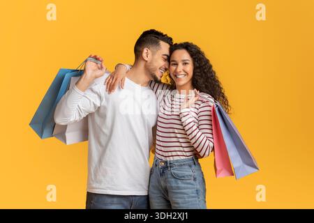 Romantisches Junges Arabisches Paar, Das Einkaufstüten Hält Und Umarmt Stockfoto