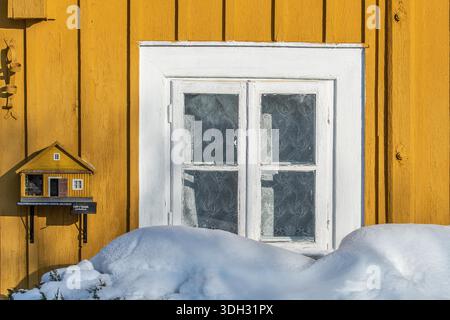 Alte litauische schöne traditionelle Holzhäuser in der Altstadt von Trakai, Litauen, an einem sonnigen Wintertag mit Schnee Stockfoto
