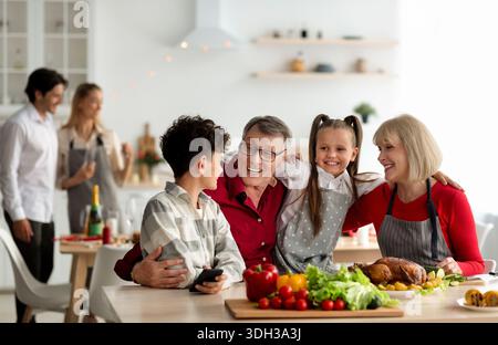 Große Familie mit mehreren Generationen, Enkelkindern und Großeltern, die festliches Thanksgiving oder Weihnachtsessen machen Stockfoto