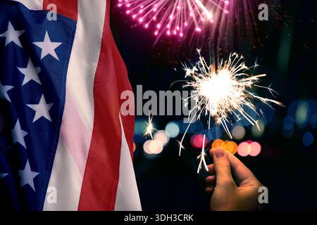 Frau, die brennenden Funkeln neben amerikanischer Flagge unter brennendem Feuerwerk im Freien hält. Design der Grußkarte für nationale Feiertage Stockfoto
