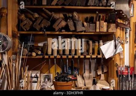 Set von Holzbearbeitungswerkzeugen, gehängte Wandschreinerei, Schnitzerei. Verschiedene Meißel, Bohrstifte in der Handwerkstatt. Heimwerkergeräte Stockfoto