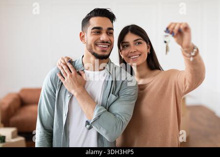 Glückliches Paar, das die Schlüssel ihrer Wohnung zeigte Stockfoto