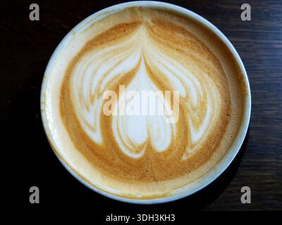 Blick von oben auf Cappuccino Coffee Cup mit Herzschaum auf schwarzem Hintergrund. Stockfoto