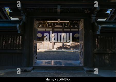 ISE, Japan - 29. Oktober 2023: Das Eingangstor der Kaguraden-Halle in Ise Jingu ist offen und zeigt den Innenhof und den mit violetten Vorhängen verzierten Saal mit weißen Emblemen. Stockfoto