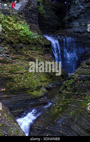 Kleiner Wasserfall, der durch eine enge Schlucht mit moosigem Gestein fließt. Stockfoto
