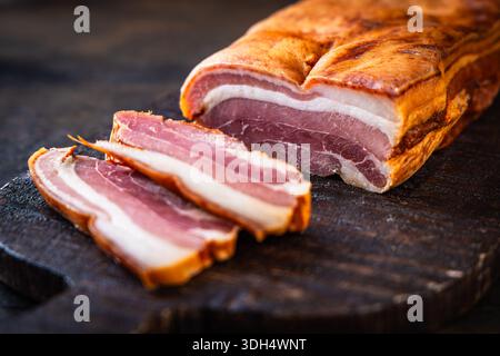 Geräucherter Schweinebauch auf Schneidebrett Stockfoto