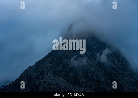 Der felsige Gipfel des Tryfan, teilweise verdeckt durch eine niedrige Wolke in Snowdonia Stockfoto