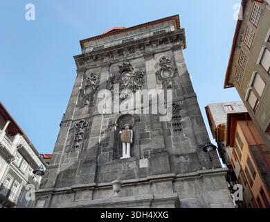 Porto, Portugal, 20. Mai 2025: Flacher Blick auf das historische Steingebäude mit ornamentaler Fassade, skulpturalen Details und einer lustigen Statue in einer Nische. Bogen Stockfoto