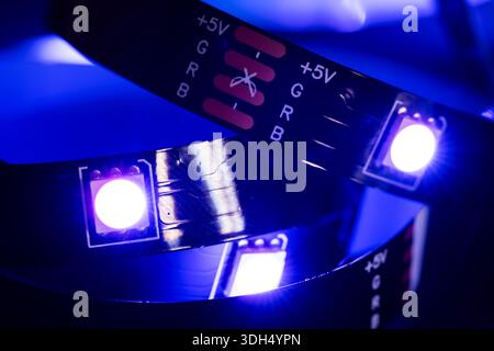 RGB-LED-Streifenlicht auf metallischer Hintergrundbeleuchtung in blauer Farbe, elektrische Geräte. Stockfoto