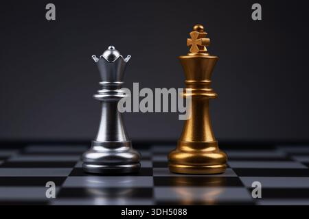 Der goldene König und die silberne Königin aus einem Schach im Dunkeln. Stockfoto