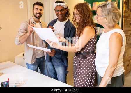 Eine vielfältige Gruppe von Kollegen führte eine lebhafte Diskussion, tauschte Ideen aus und arbeitete in einem hellen, modernen Coworking-Raum zusammen, um die Kreativität zu fördern Stockfoto