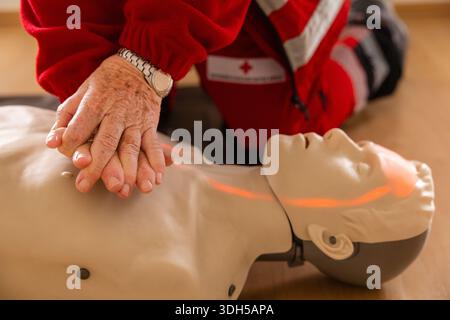 Eine Person, die die HLW an einer Schulpuppe übt und in einer erste-Hilfe-Werkstatt praktische Techniken betont. Ideal für erste-Hilfe-Trainingsprogramme und HE Stockfoto