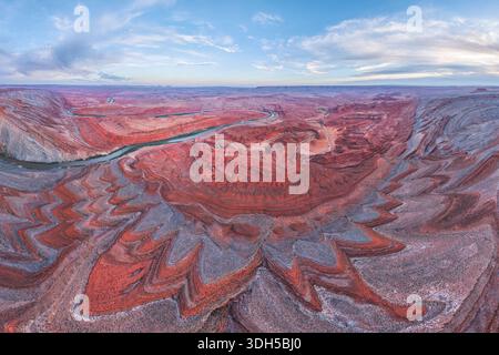 Majestätische Aussicht auf den San Juan River, der sich durch leuchtende rote Felsformationen in Utah, USA, unter einem riesigen Himmel schlängelt und die schroffe Schönheit von zeigt Stockfoto