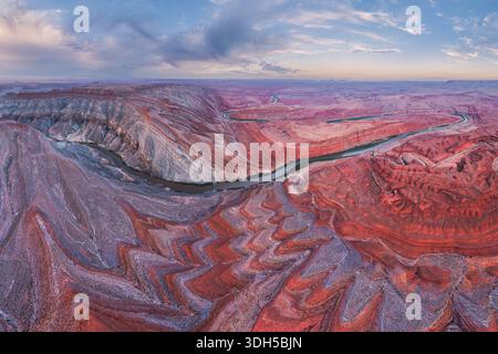Der San Juan River schlängelt sich durch die dramatischen Canyonlandschaften Utahs und zeigt lebendige rote Felsformationen unter einem riesigen Himmel. Diese atemberaubende Aussicht ist hoch Stockfoto