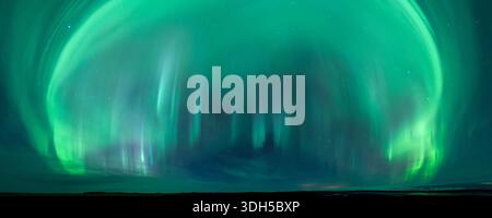 Faszinierendes Panorama der aurora Borealis, das den Nachthimmel in lebendigen Grüntönen erleuchtet. Die ätherischen Lichter sorgen für eine atemberaubende visuelle Anzeige gegenüber einem Stockfoto