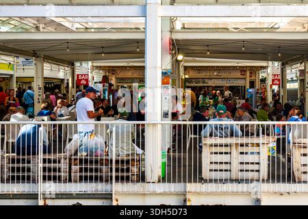 Der Food Court im Mercato Testaccio, Rom, Italien, wo Menschen unter einer überdachten Marktstruktur essen. Stockfoto