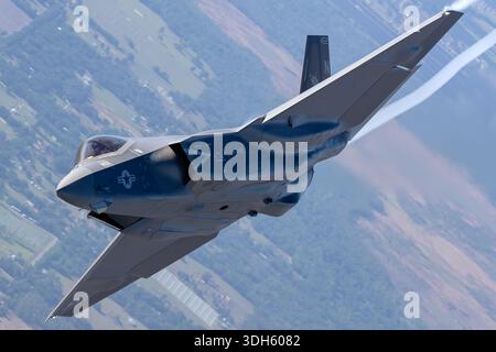 Abgebildet ist ein Lockheed Martin F-35C Lightning II der VFA-125 Rough Raiders der US Navy, der 2025 auf der Sun N Fun Aerospace Expo in Florida in einem Bankmanöver mit sichtbarem Dampfpfad fliegt. Registriert NJ-452, zeigt dieser einsitzige, einsitzige Stealth-Mehrzweckjäger den Piloten im Cockpit. Der F-35C wird von einem Pratt & Whitney F135-PW-100 Turbofan-Motor mit Klappflügeln, verstärktem Fahrwerk und fortschrittlicher Avionik für den Trägerbetrieb angetrieben. Stockfoto