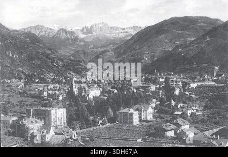 Bozen-Gries liegt in der alpinen Gelassenheit in dieser Ansicht aus den späten 1920er Jahren, die von Lorenz Franzl veröffentlicht wurde. Kirchtürme erheben sich zwischen terrassenförmig angelegten Hängen und kunstvoll verzierten Dächern, eingerahmt von dramatischen Berggipfeln. Die vielschichtige Architektur und das bebaute Tal der Stadt spiegeln Südtirols Mischung aus italienischem und österreichischem Erbe wider, die in einem ruhigen Moment der europäischen Landschaft zwischen den Kriegen festgehalten wird. Von einer original gedruckten Postkarte: Stockfoto