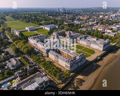 Blick aus der Vogelperspektive auf das historische Old Royal Naval College mit seiner symmetrischen Architektur und gepflegten Rasenflächen vor dem Hintergrund der Themse, Lo Stockfoto