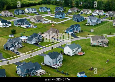 Zweistöckige Privathäuser mit geringer Dichte und großem Grundstück und grünen Rasenflächen in der Sommersaison. Ländliche Vororte mit gehobenem Vorort Stockfoto
